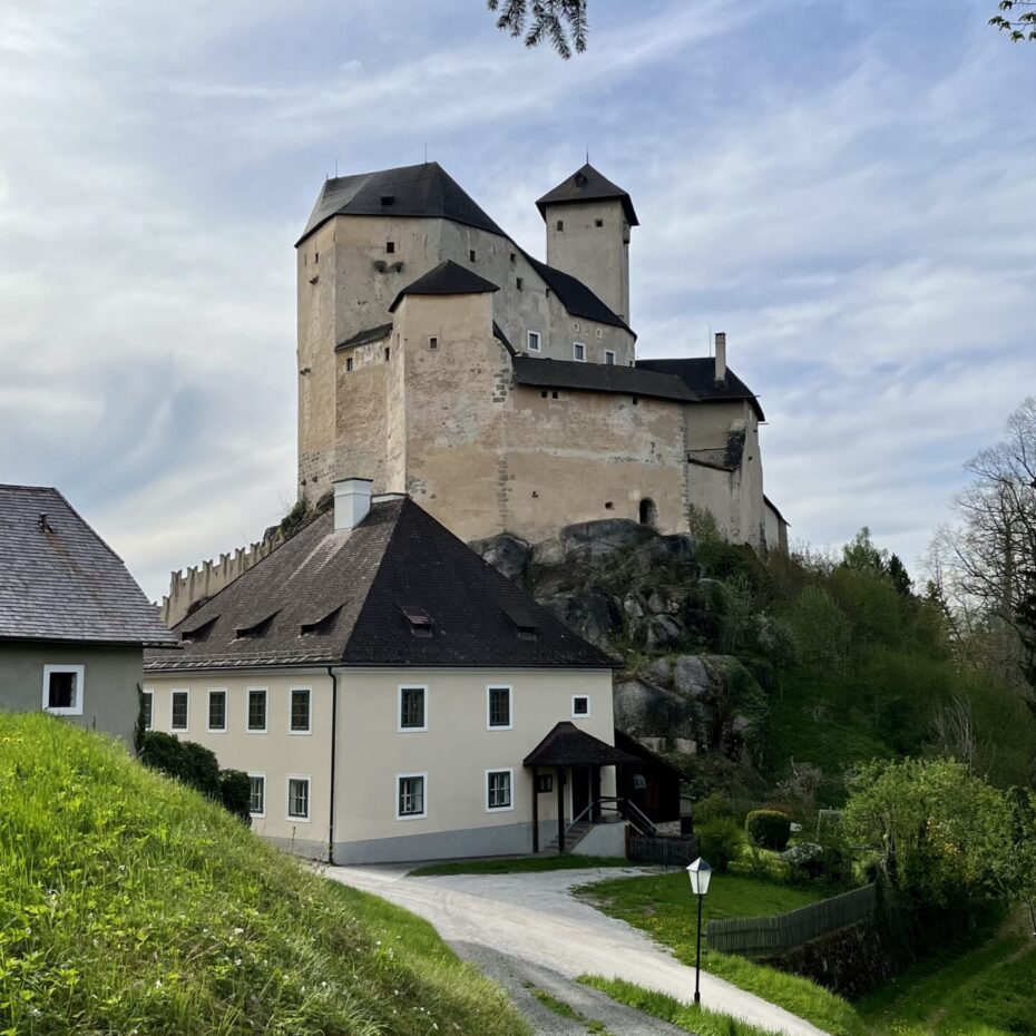 eine Burg mit einem Wirtschaftsgebäude im Vordergrund